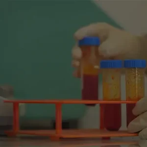 کارشناس آزمایشگاه حین کار با دستگاه و لوله‌های آزمایش