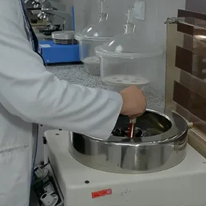 کارشناس آزمایشگاه در حال گذاشتن لوله ها داخل دستگاه سانتریفیوژ