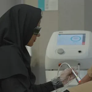 اپراتور بیمارستان درحال کار با دستگاه لیزر