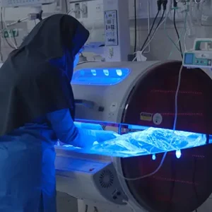 پرستار در حال مراقبت از نوزاد داخل دستگاه