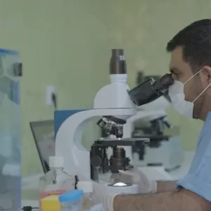 کارشناس آزمایشگاه درحال کار با میکروسکوپ
